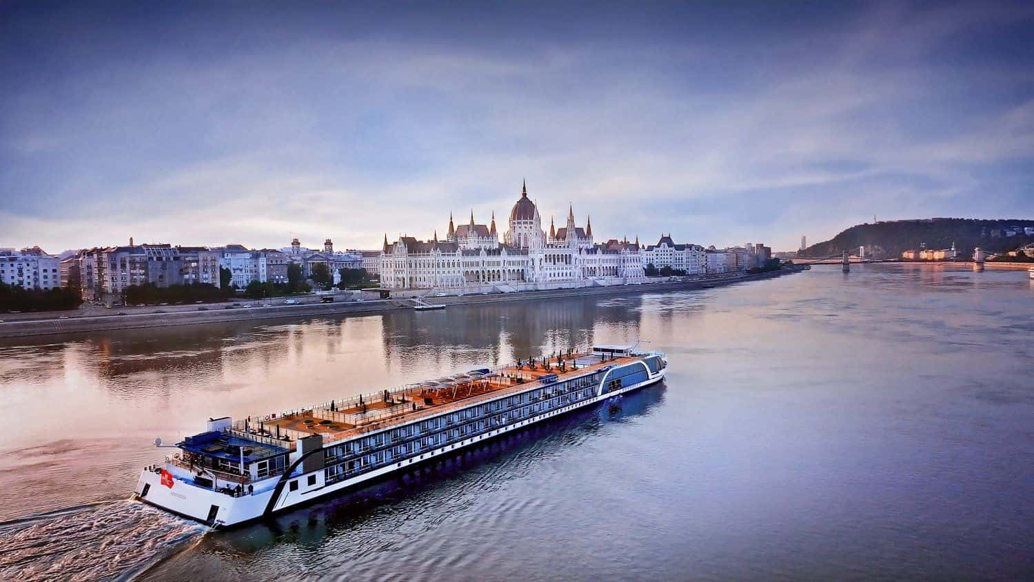 A luxury European river cruise ship on the Danube at dusk in Budapest